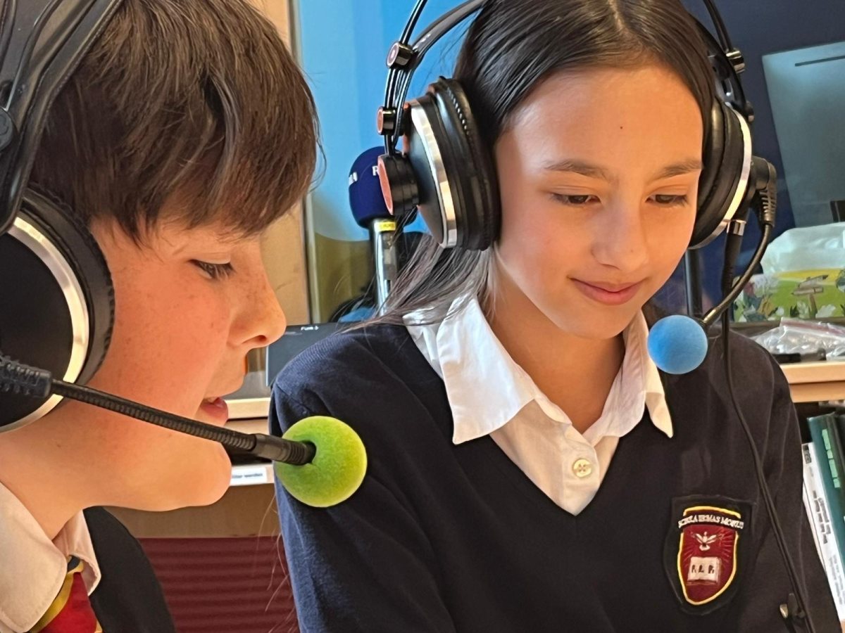 Schülerin und Schüler mit Kopfhörern im Radiostudio