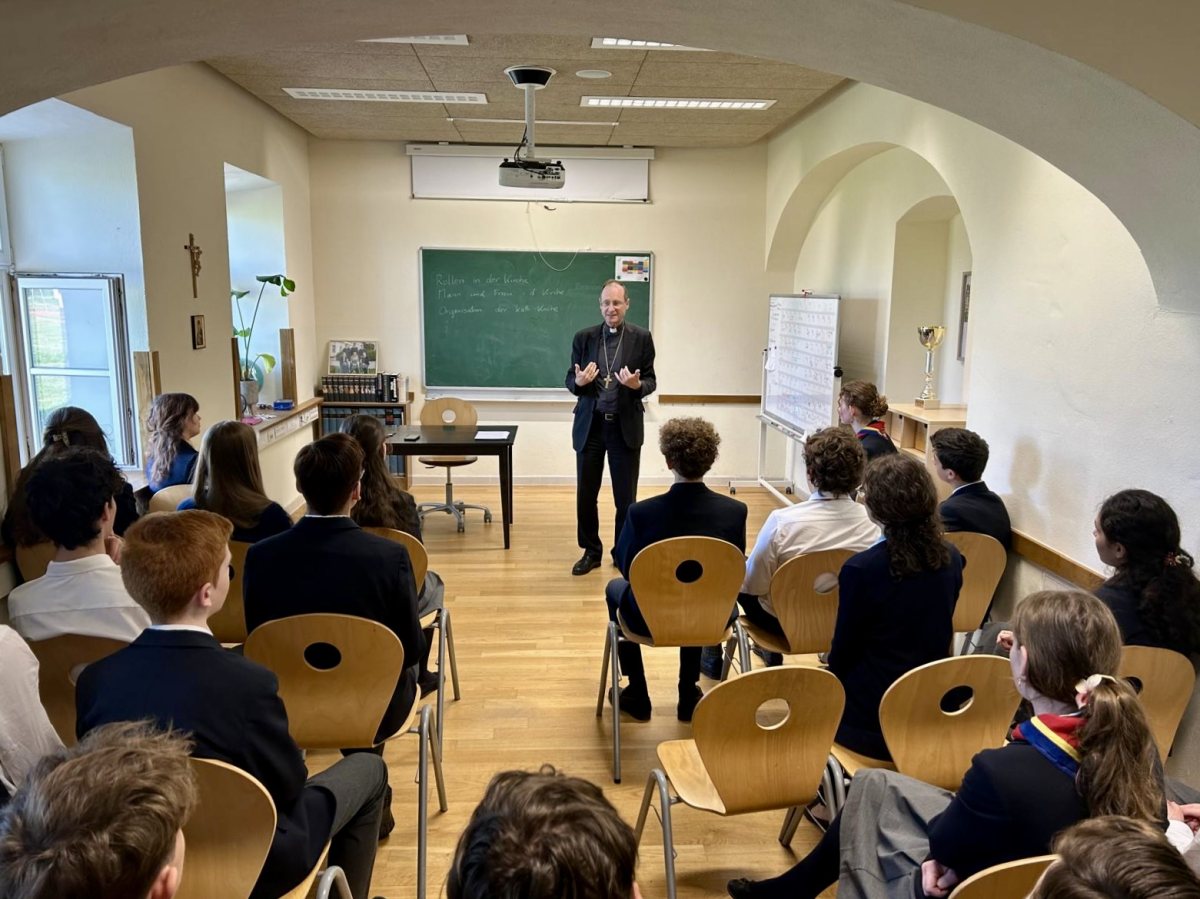 Ein Geistlicher spricht vor Schülerinnen und Schülern der Oberstufe