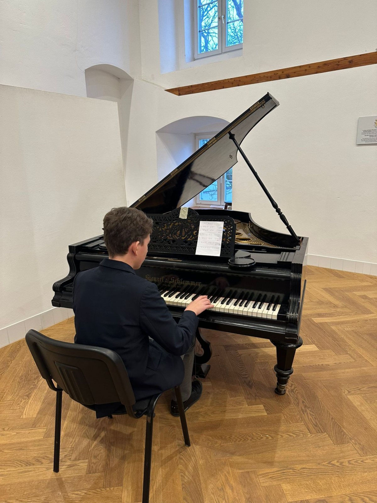 Ein Schüler spielt Klavier am Flügel